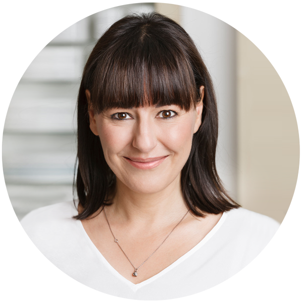 Portrait von Barbara Nier, lächelt in die Kamera, braune Haare mit geradem Pony und braunen Augen