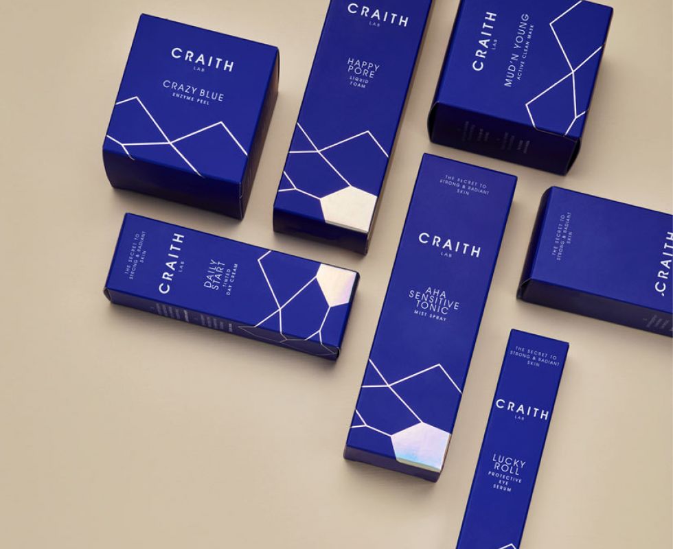 Verschiedene Produkte der Blue Collection in blauen Schachteln mit goldener Beschriftung symetrisch angeordnet