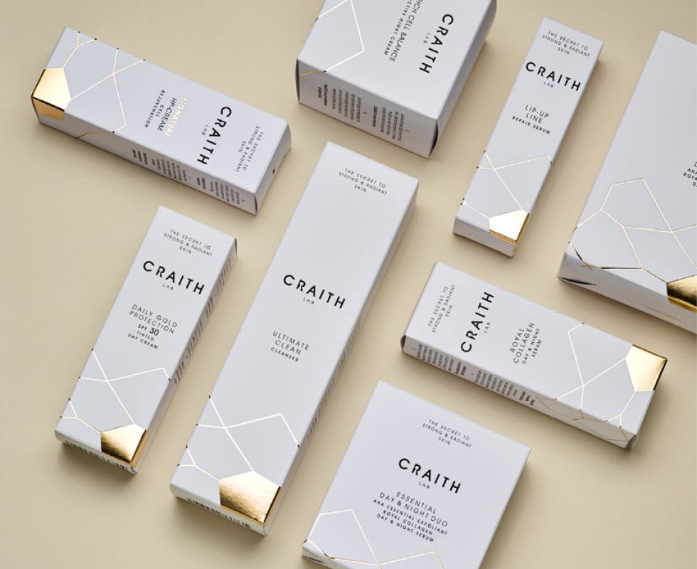 Verschiedene Produkte der Gold Collection in weißen Schachteln mit goldener Beschriftung symetrisch angeordnet