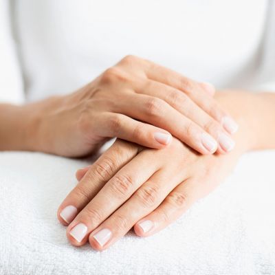 Gepflegte Hände mit weiß lackierten Fingern in Großaufnahme